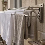 Étendoir à linge extérieur rétractable sur balcon urbain, draps et serviettes